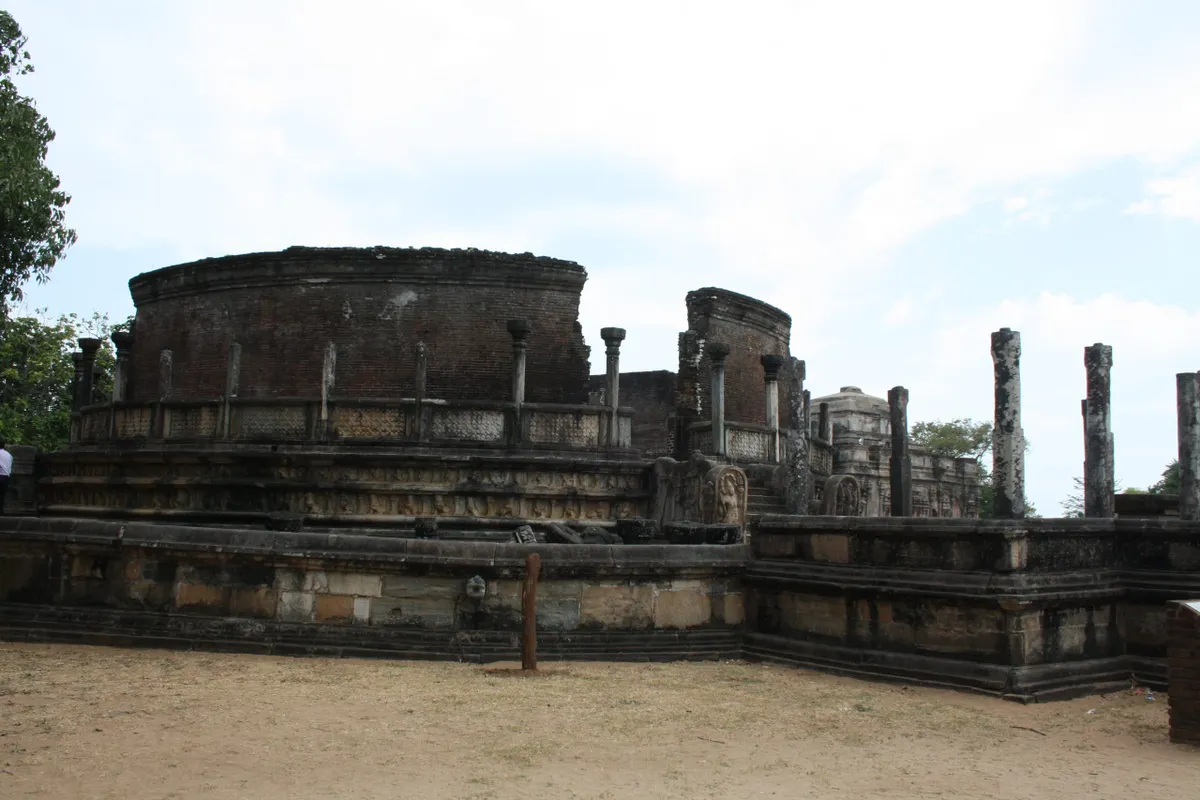 Sunlit ancient brick ruins scattered among trees at Polonnaruwa