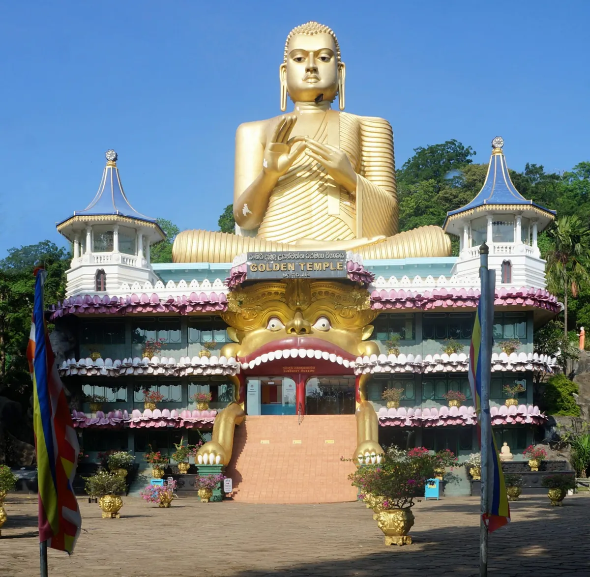 The golden Buddha statue and temple complex at the foot of Dambulla rock