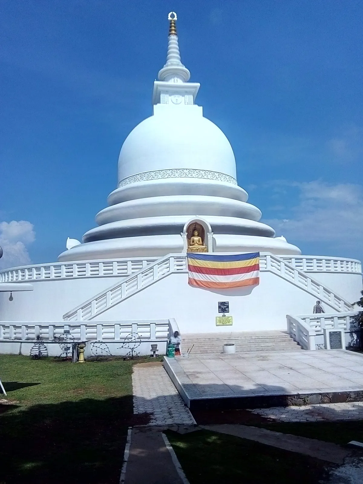 The white Japanese Peace Pagoda above Unawatuna, glowing in late-afternoon light