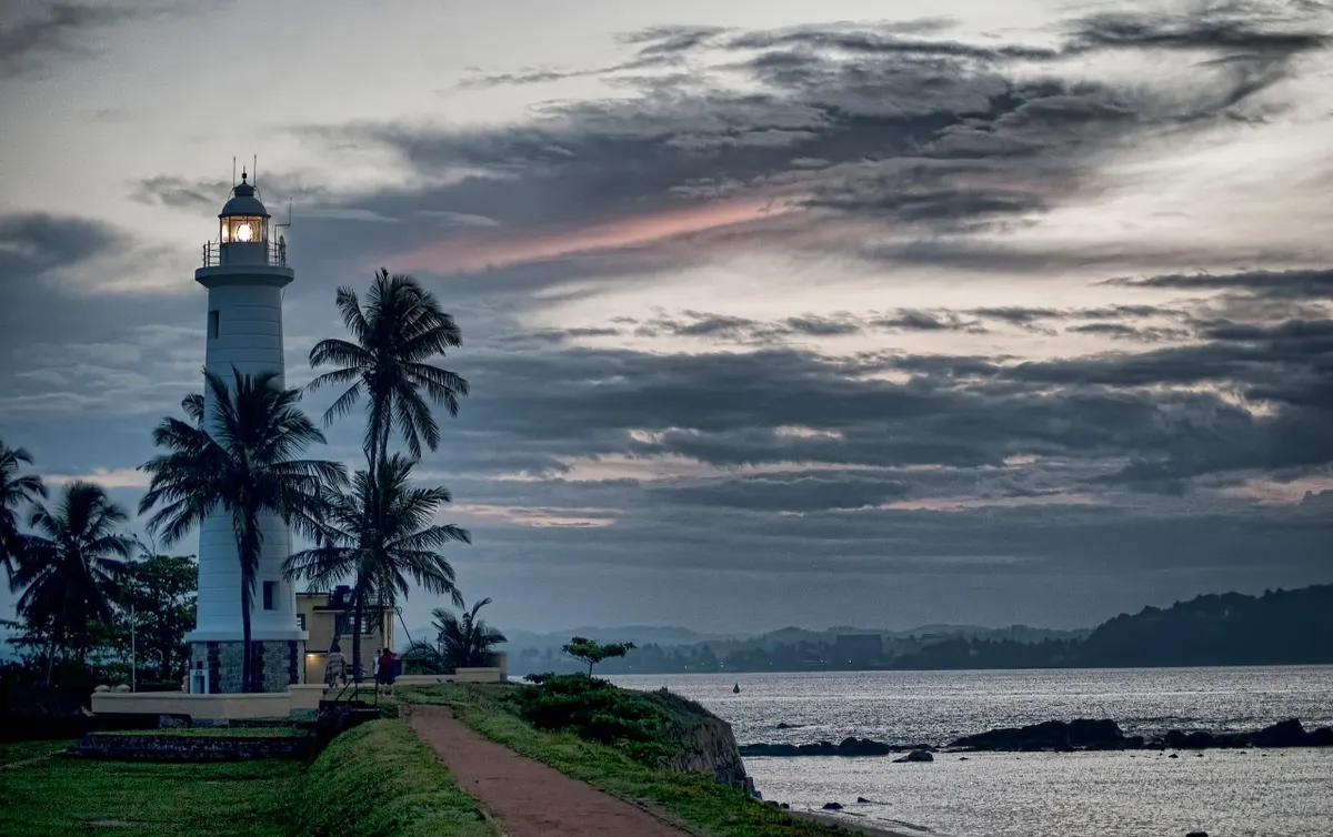 The white lighthouse and palm trees on the ramparts of Galle Fort