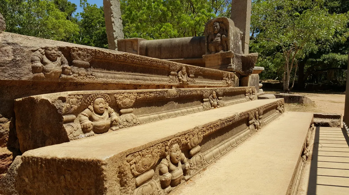 An intricately carved ancient moonstone threshold at Anuradhapura