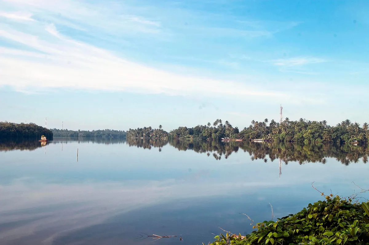 Boats moored on the calm Bentota River behind the beach