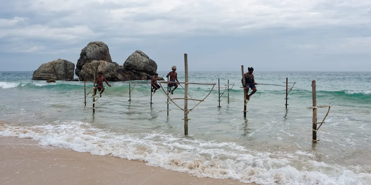 Stilt fishermen balanced over the surf on Sri Lanka's south coast