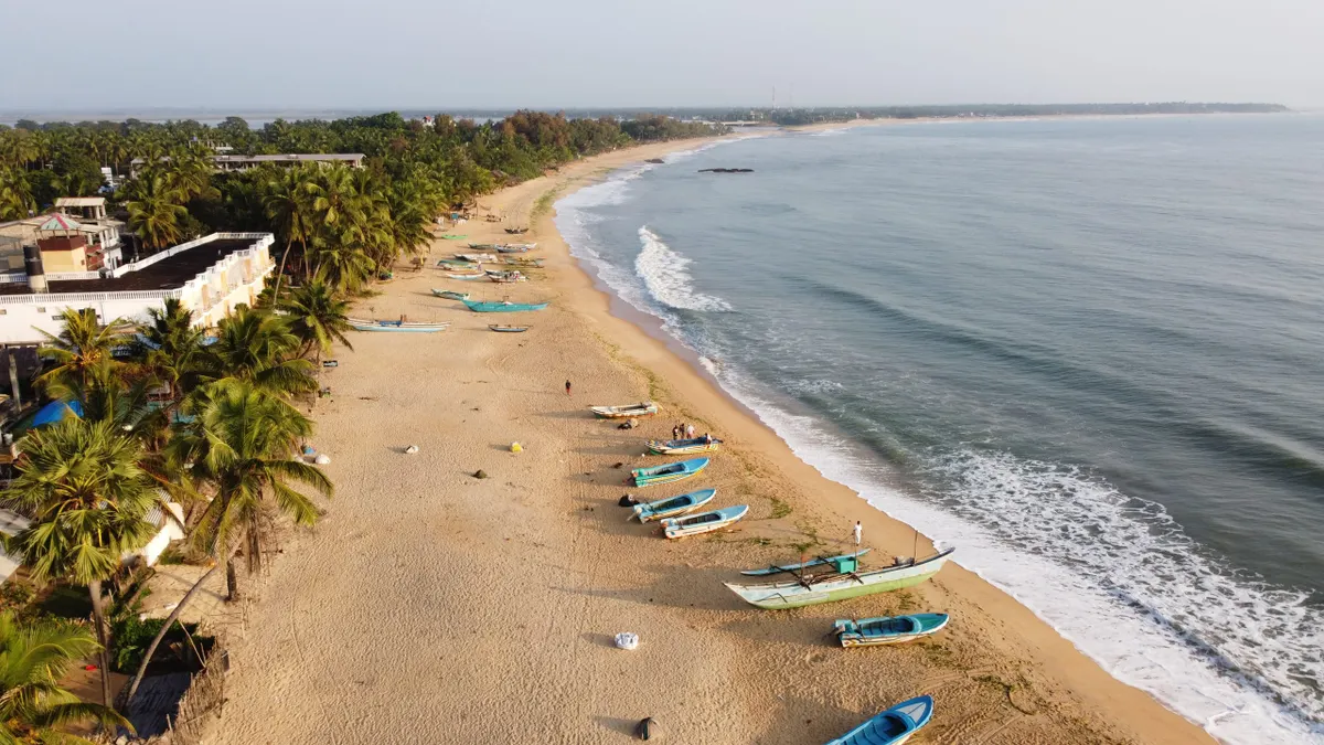 Fishing boats on the curve of Arugam Bay from above