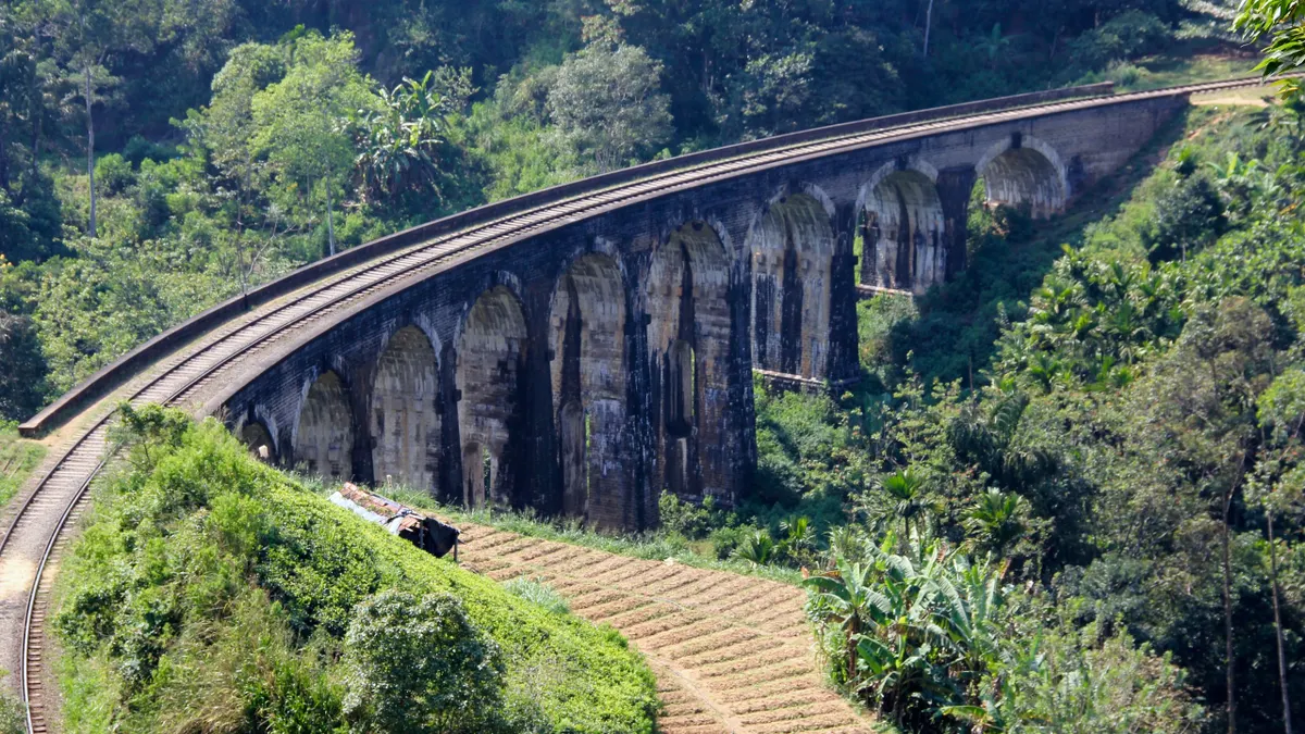 The Nine Arch Bridge curving through tea and jungle near Ella