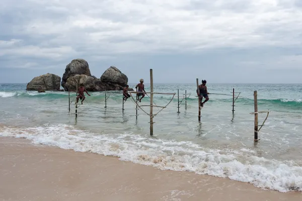Stilt fishermen balanced over the surf on Sri Lanka's south coast